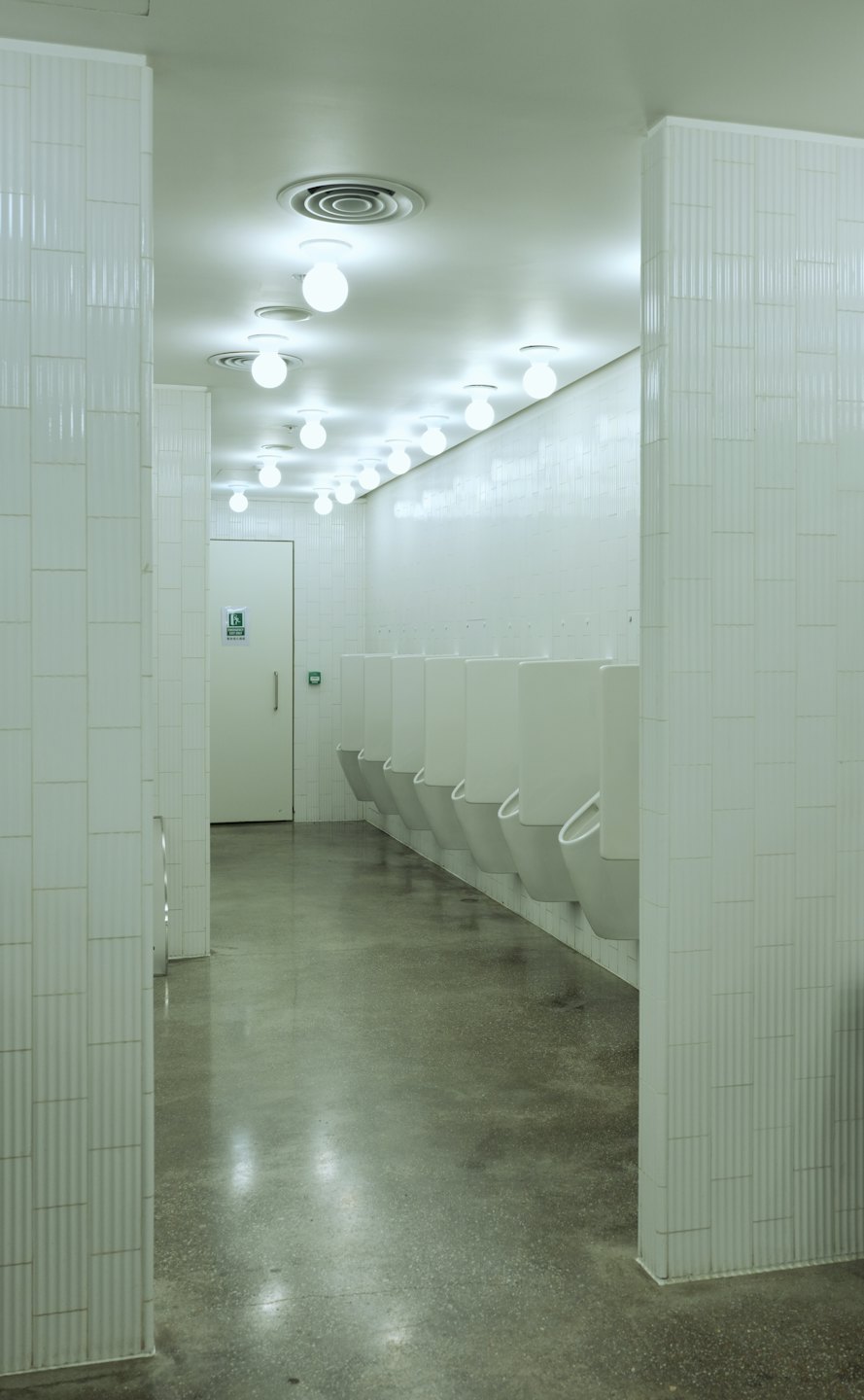 Row of white urinals along a tiled wall in a restroom.